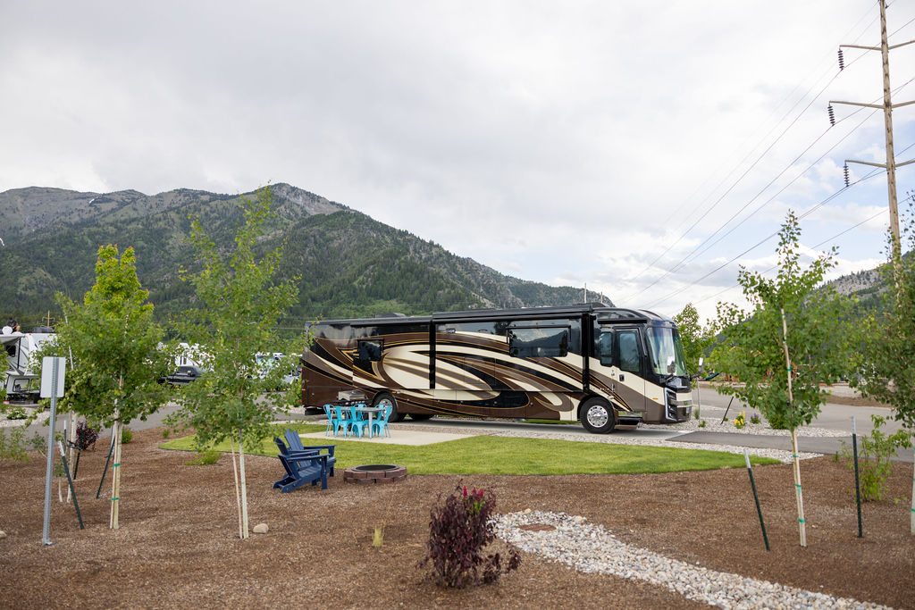 A large brown RV in a pull-through RV site.